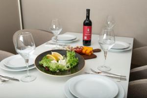 - une table avec une assiette de nourriture et des verres à vin dans l'établissement Batumi allince Palace, à Batoumi