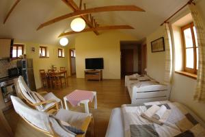 a living room with white chairs and a television at Penzion Hradební in Telč