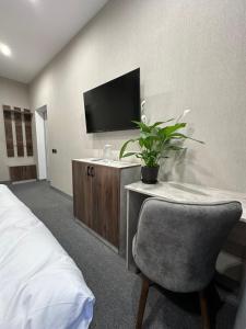 a bedroom with a desk with a chair and a tv at TURAN HOTEL in Aktau