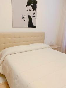 a bed in a bedroom with a picture on the wall at Appartamento al Lago in Castiglione del Lago