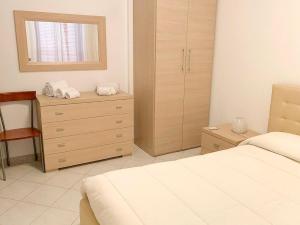 a bedroom with two beds and a dresser and a window at Appartamento al Lago in Castiglione del Lago