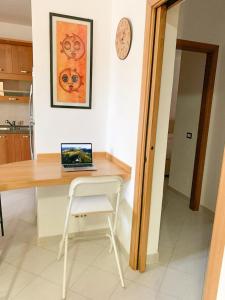 a kitchen with a desk with a laptop on it at Appartamento al Lago in Castiglione del Lago