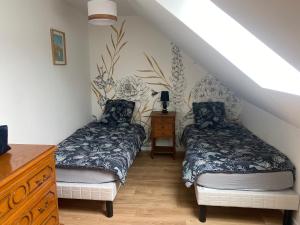 a bedroom with two beds and a dresser at Gîte à la ferme de la Corbinais in Saint-Cast-le-Guildo