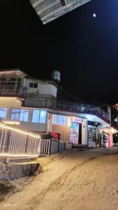 un edificio con una valla delante de él por la noche en Heena Guest House, en Dharamshala