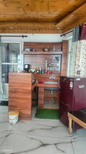 cocina con fregadero y nevera en Heena Guest House, en Dharamshala