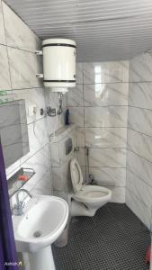 y baño con aseo blanco y lavamanos. en Heena Guest House, en Dharamshala