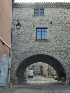 una entrada a un edificio de piedra con un arco en Les randonnées joyeuses en Génolhac