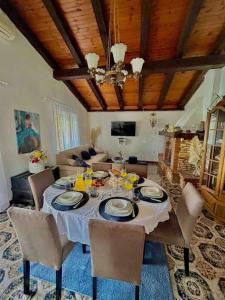 a dining room with a table with chairs and a couch at Vila La Perla Istriana in Višnjan