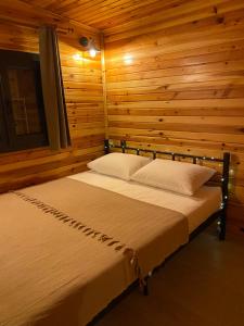 Ardeşen的住宿－Ritiny House，木制客房内的一间卧室,配有一张床
