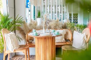 a dining room table with a wooden table and chairs at The Color Kata in Kata Beach
