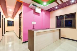 Jogeshwāri的住宿－OYO Hotel Raigad Inn，大堂设有粉红色的墙壁和前台
