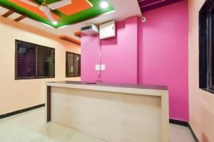 Jogeshwāri的住宿－OYO Hotel Raigad Inn，一间有柜台的房间的粉红色墙壁