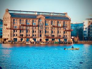 un homme dans un bateau dans l'eau devant un bâtiment dans l'établissement Schöne Aussichten mitten in Berlin - il sole, à Berlin