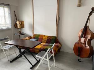 une chambre avec un violon, une table et une guitare dans l'établissement Le Studio Robespierre, à Ivry-sur-Seine