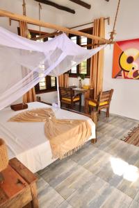 a bedroom with a bed with a mosquito net at Z-Lodge Zanzibar in Kiwengwa