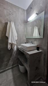 y baño con lavabo, espejo y toallas. en Villa Kavalino en Kolymbia