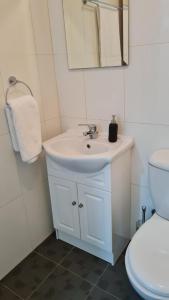 a bathroom with a white sink and a toilet at The Olive Grove Escape, Eleonas Apts in Sotira +24 photos