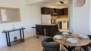 eine Küche und ein Esszimmer mit einem Tisch und Stühlen in der Unterkunft Eleonas Garden Apartments in Sotira