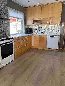 a kitchen with wooden cabinets and white appliances at Solhøgda in Sortland