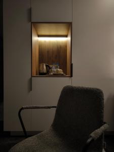 a chair sitting in a room with a cabinet at London Hotel Yerevan in Yerevan