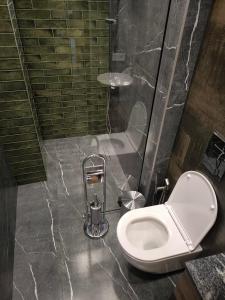 a bathroom with a white toilet and a shower at London Hotel Yerevan in Yerevan