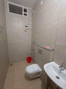 een witte badkamer met een toilet en een wastafel bij Happy HomeStay In Pondicherry in Pondicherry
