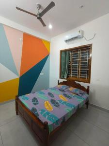 een slaapkamer met een bed met een kleurrijke muur bij Happy HomeStay In Pondicherry in Pondicherry