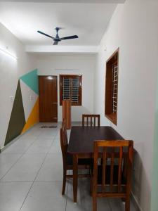 een eetkamer met een tafel en stoelen en een plafond bij Happy HomeStay In Pondicherry in Pondicherry