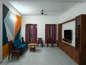 een woonkamer met een blauwe bank en een tv bij Happy HomeStay In Pondicherry in Pondicherry