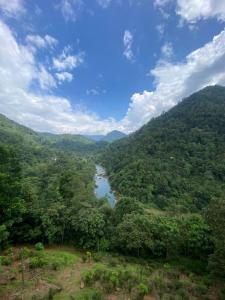 vista para um rio no meio de uma montanha em Adventure Base camp em Kitulgala