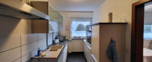 eine kleine Küche mit Spüle und Fenster in der Unterkunft FewoEla2 Große Ferienwohnung in Eppstein bei Frankfurt in Eppstein