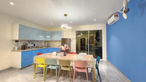 cocina con mesa con sillas y armarios azules en La Belle Maison 12 @ Gurney Kelawai/Pulau Tikus/Georgetown en George Town
