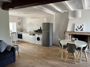 a kitchen and living room with a table and a table and chairs at Gîte Le Polochon in Varennes-le-Grand