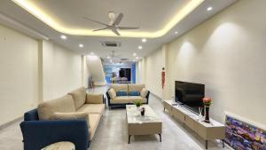 - un salon avec un canapé et une télévision dans l'établissement La Belle Maison 12 @ Gurney Kelawai/Pulau Tikus/Georgetown, à George Town