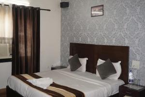 1 dormitorio con 1 cama grande con sábanas blancas en Tipsyy inn 017, en Gurgaon
