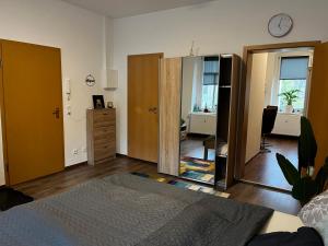 Schlafzimmer mit einem Bett, einer Kommode und einem Spiegel in der Unterkunft Karli‘s Plätzchen in Gera