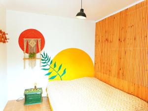 um quarto com uma cama e uma grande cabeceira em madeira em Be a Guest at PachaMama Community em Alcácer do Sal