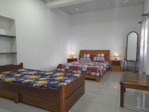 アンツィラベにあるChez Joëlのベッドルーム1室(ベッド2台、テーブル付)