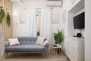 a living room with a blue couch and a tv at Charming Apartment next to Roman Amphitheater in Pula