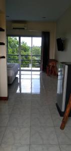 a living room with a large glass door to a balcony at Be Fine Sabuy Hotel and Resort in Surat Thani