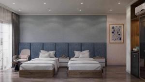 een slaapkamer met 2 bedden en een blauwe muur bij Wonderland Villa at Hồ Tràm Beach in Xuyên Mộc