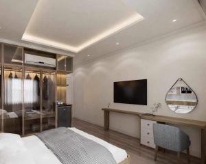 een slaapkamer met een bed en een televisie aan de muur bij Wonderland Villa at Hồ Tràm Beach in Xuyên Mộc