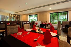 restauracja z dwoma stołami z czerwoną tkaniną w obiekcie HOTEL SAN w mieście Kollam