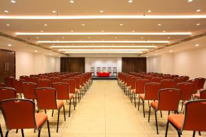 an empty room with red chairs and a stage at HOTEL SAN in Kollam