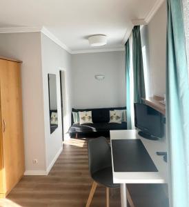 Zimmer mit einem Schreibtisch, einem Computer und einem Bett in der Unterkunft Hotel Villa Solln in München