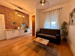 ein Wohnzimmer mit Couch und Tisch in der Unterkunft A0 Grand Appartement, Jaccuzi, et extérieur Thermal Artem à 200m in Nancy