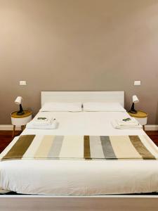 ein weißes Bett mit zwei Lampen an zwei Tischen in der Unterkunft A casa di Cesare in Rom
