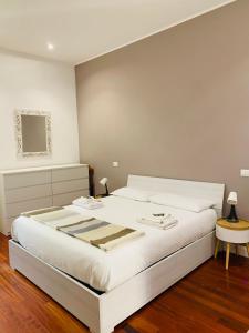 ein Schlafzimmer mit einem großen weißen Bett und einem Tisch in der Unterkunft A casa di Cesare in Rom