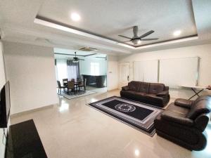 uma sala de estar com um sofá e uma mesa em Sweet Cenang Memories Inn em Pantai Cenang
