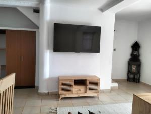 sala de estar con TV de pantalla plana en la pared en Diani Hideaway Beach Villa en Galu